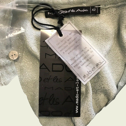 Close-up of a Mado et les Autres clothing tag on fabric.
