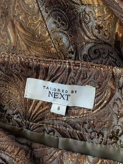 Patterned fabric with a 'Tailored by Next' label on a brown and gold background