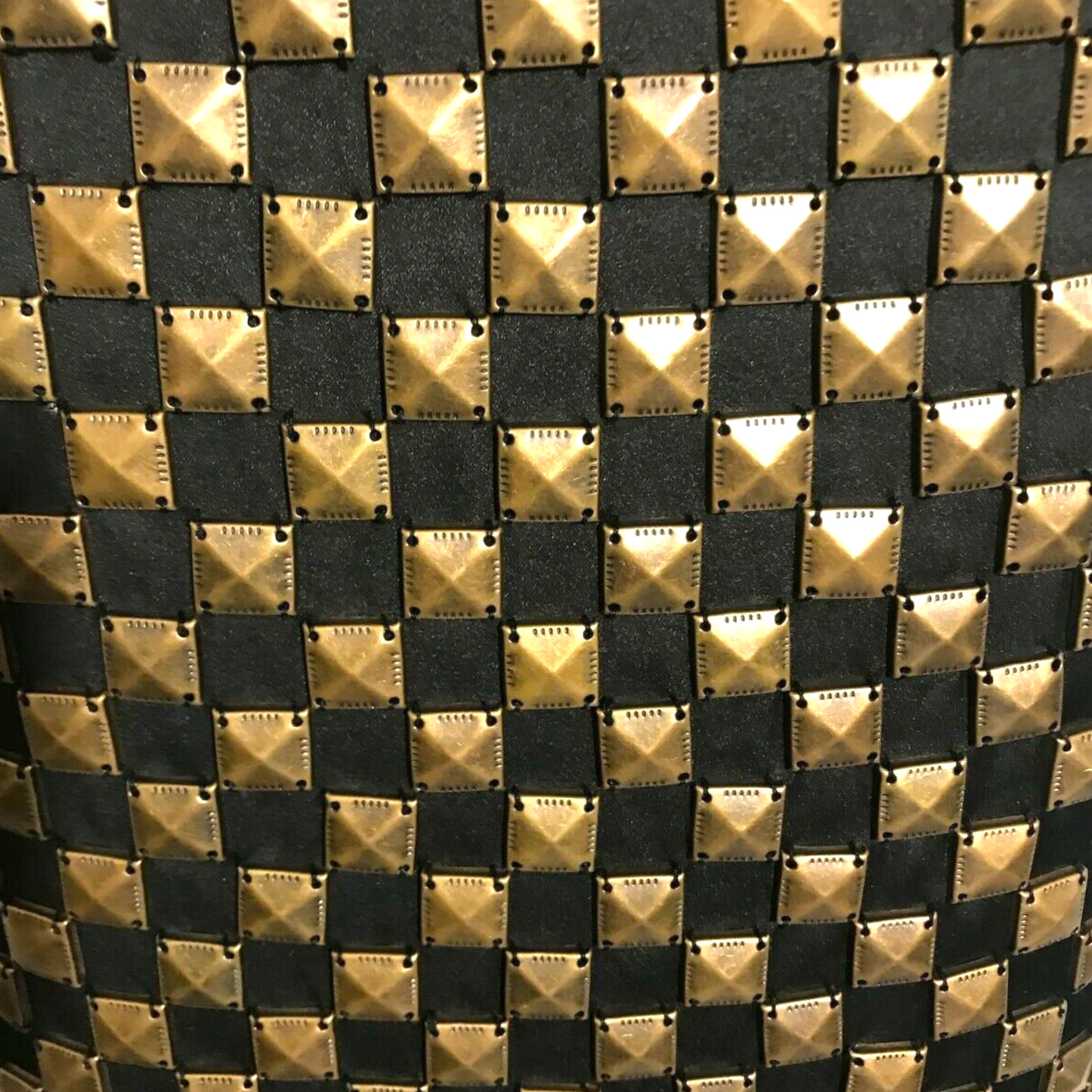 Close-up of a patterned fabric with gold and black diamond shapes.