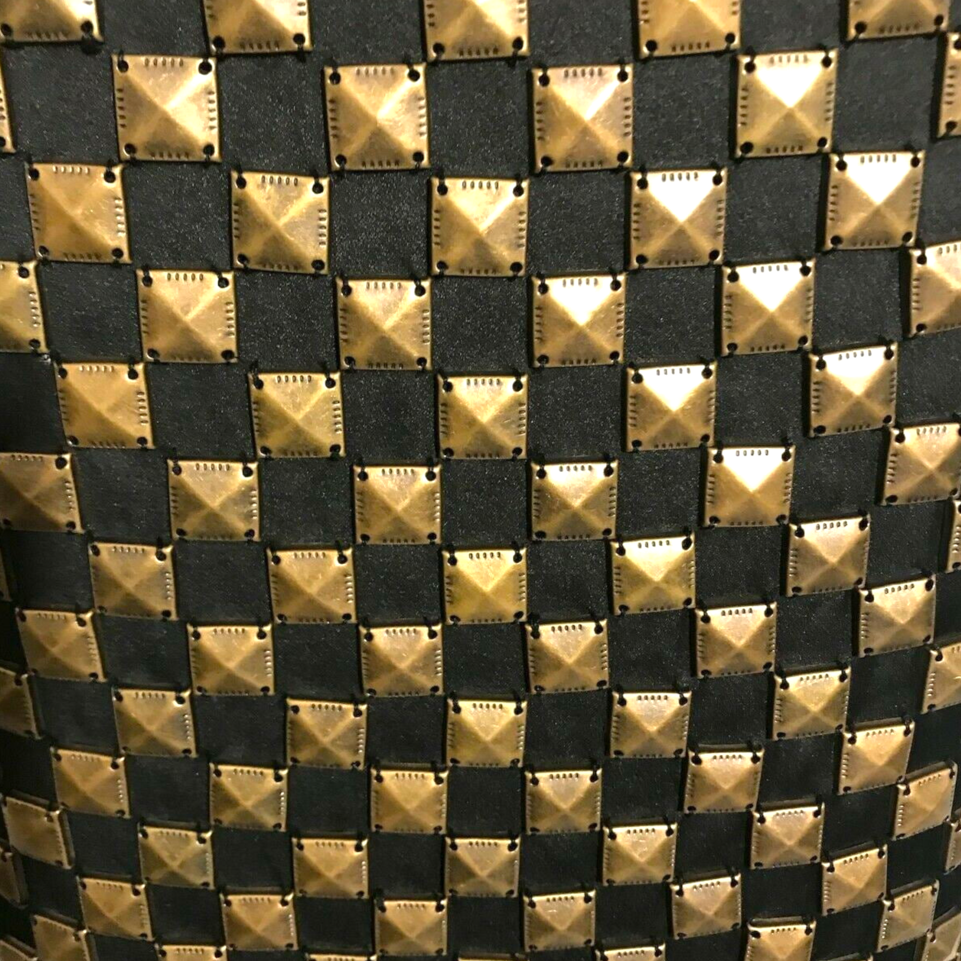 Close-up of a patterned fabric with gold and black diamond shapes.