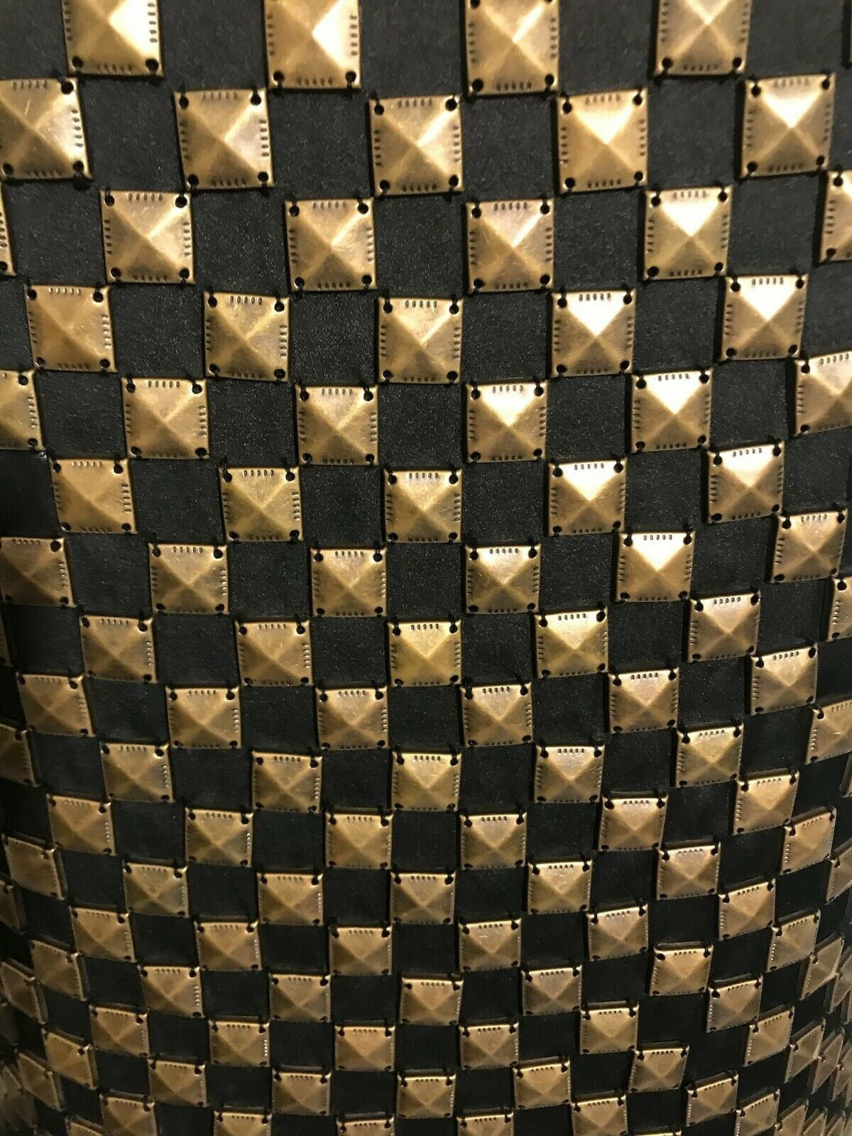 Close-up of a patterned fabric with gold and black squares.