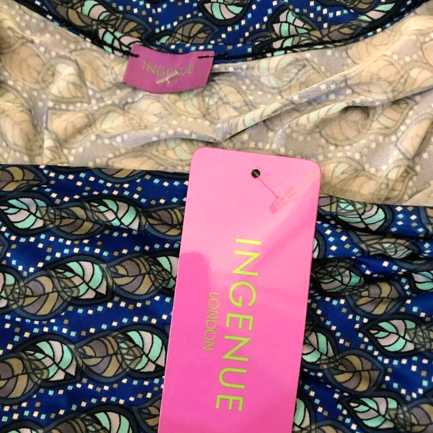Patterned fabric with a pink 'INGENUE' tag in the foreground