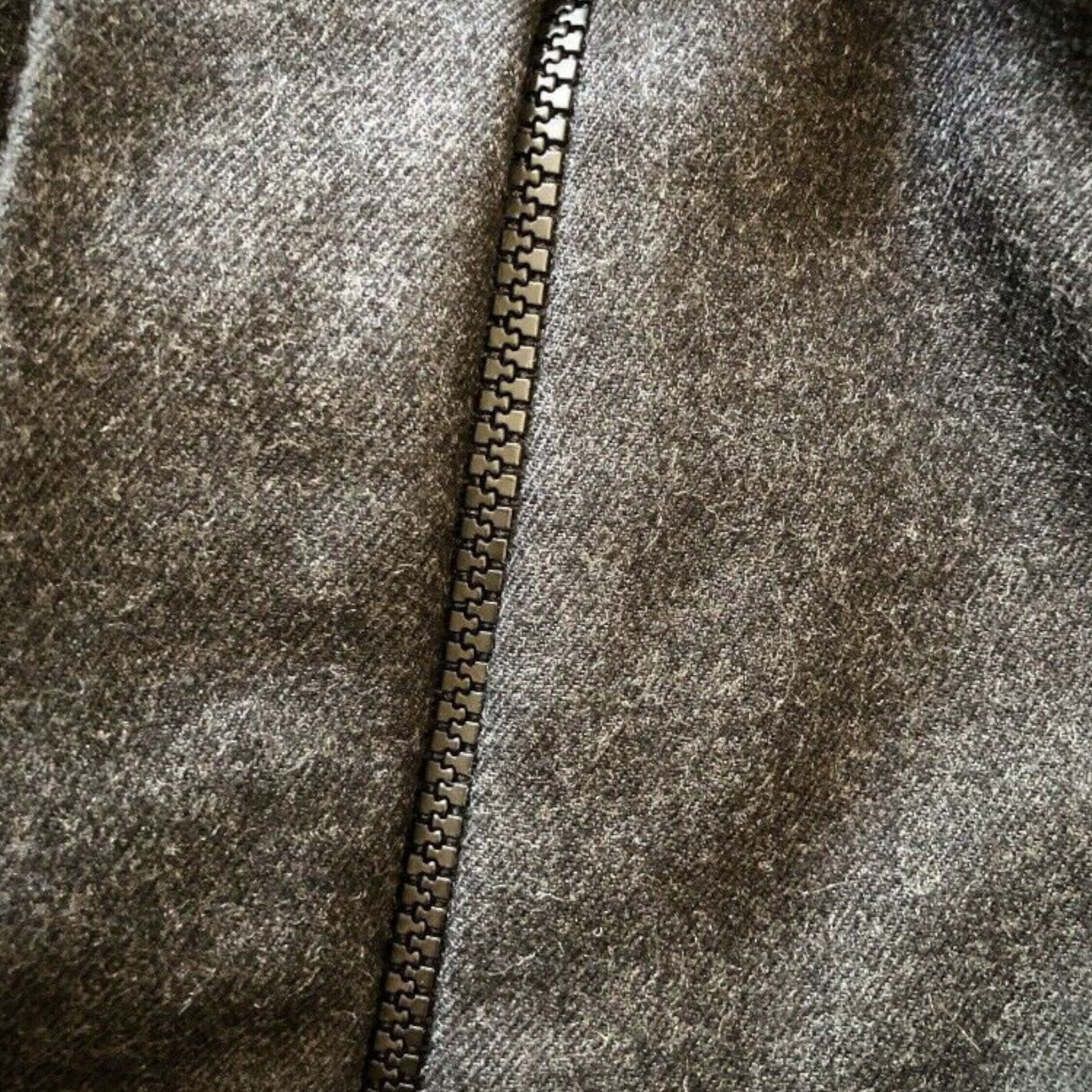 Close-up of a textured fabric with a zipper running vertically.