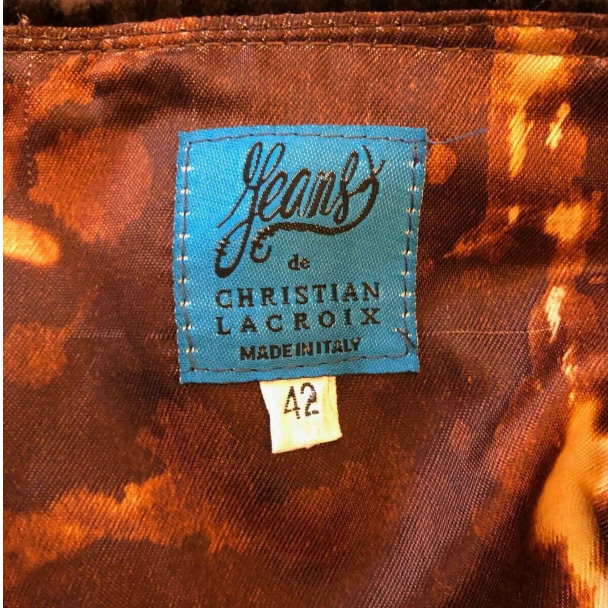 Label on tortoiseshell-patterned fabric indicating 'Jeans de Christian Lacroix Made in Italy'.