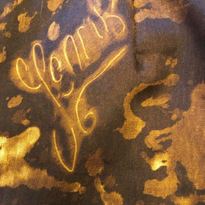 Gold text on a camouflage-patterned background