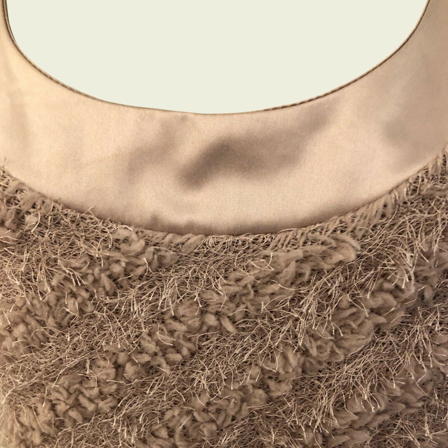 Close-up of a textured brown fabric on a beige background