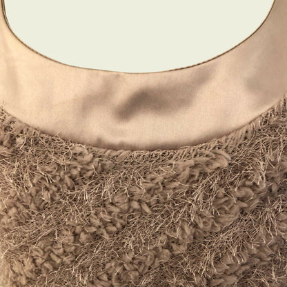 Close-up of a textured brown fabric on a beige background