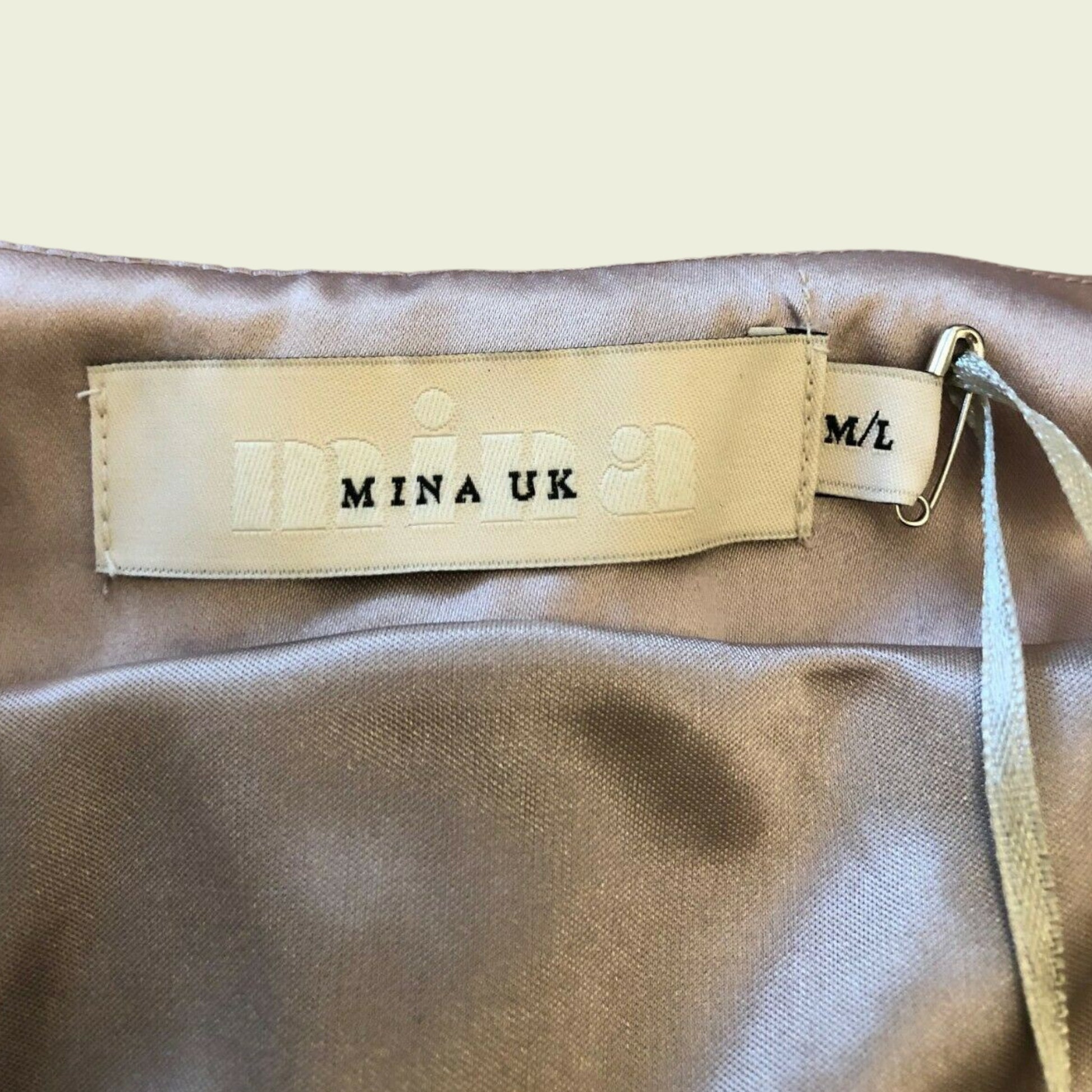 Close-up of a beige fabric with a brand label on a beige background