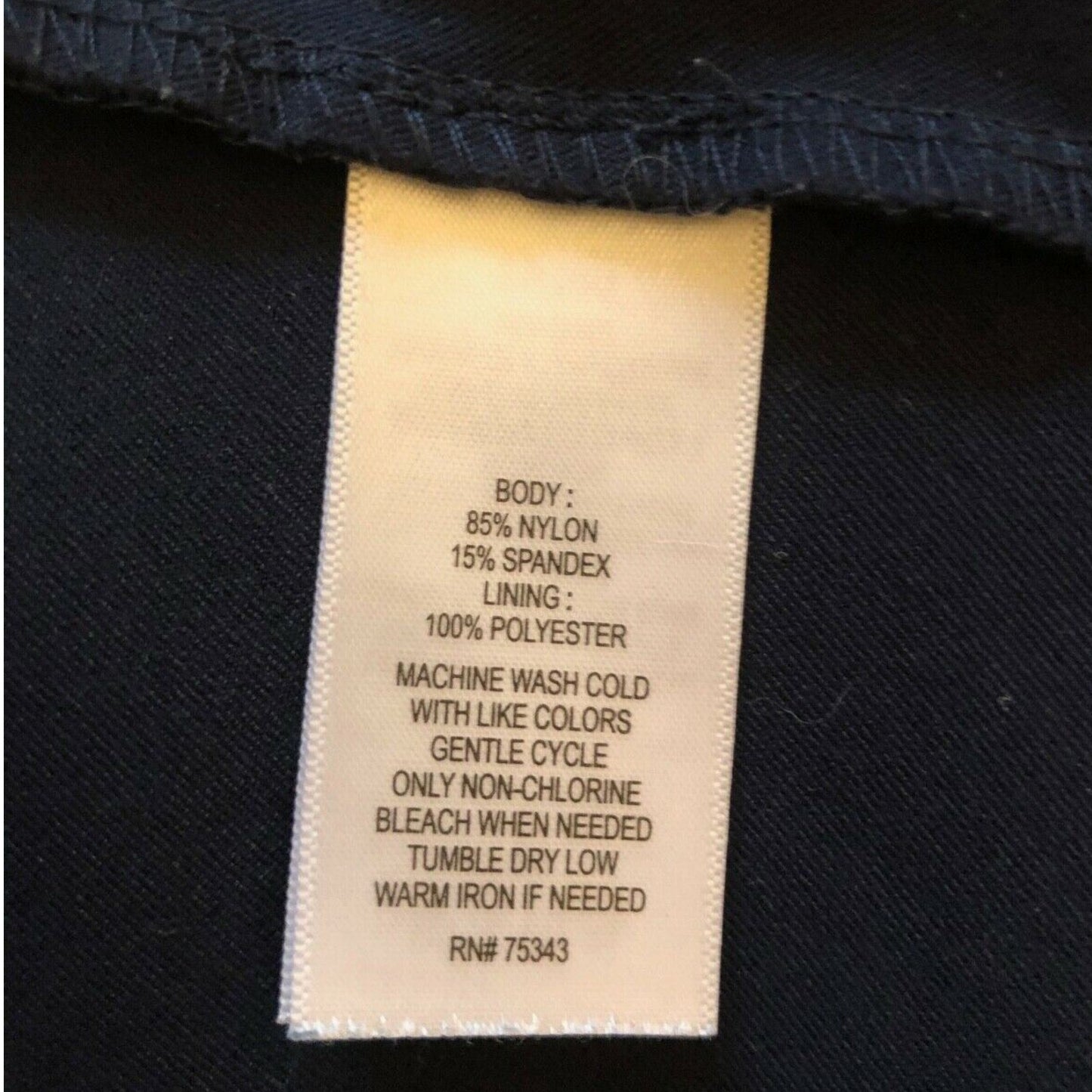 Clothing label with fabric composition and care instructions on a black background