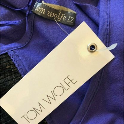 Close-up of a purple garment with a 'Tom Wolfe' tag.