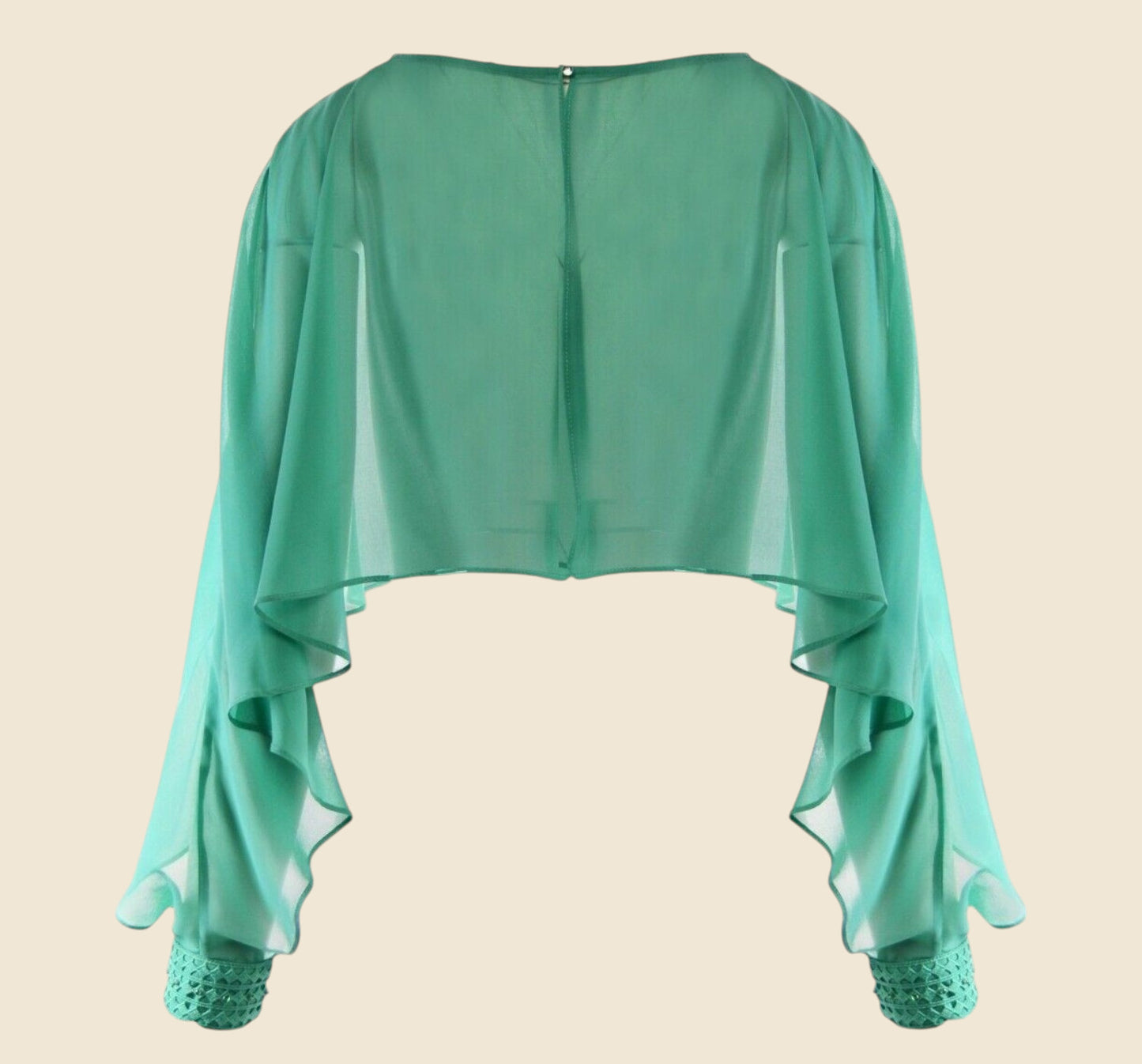 Green sheer top with lace cuffs on a beige background