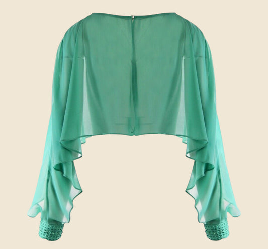 Green sheer top with lace cuffs on a beige background
