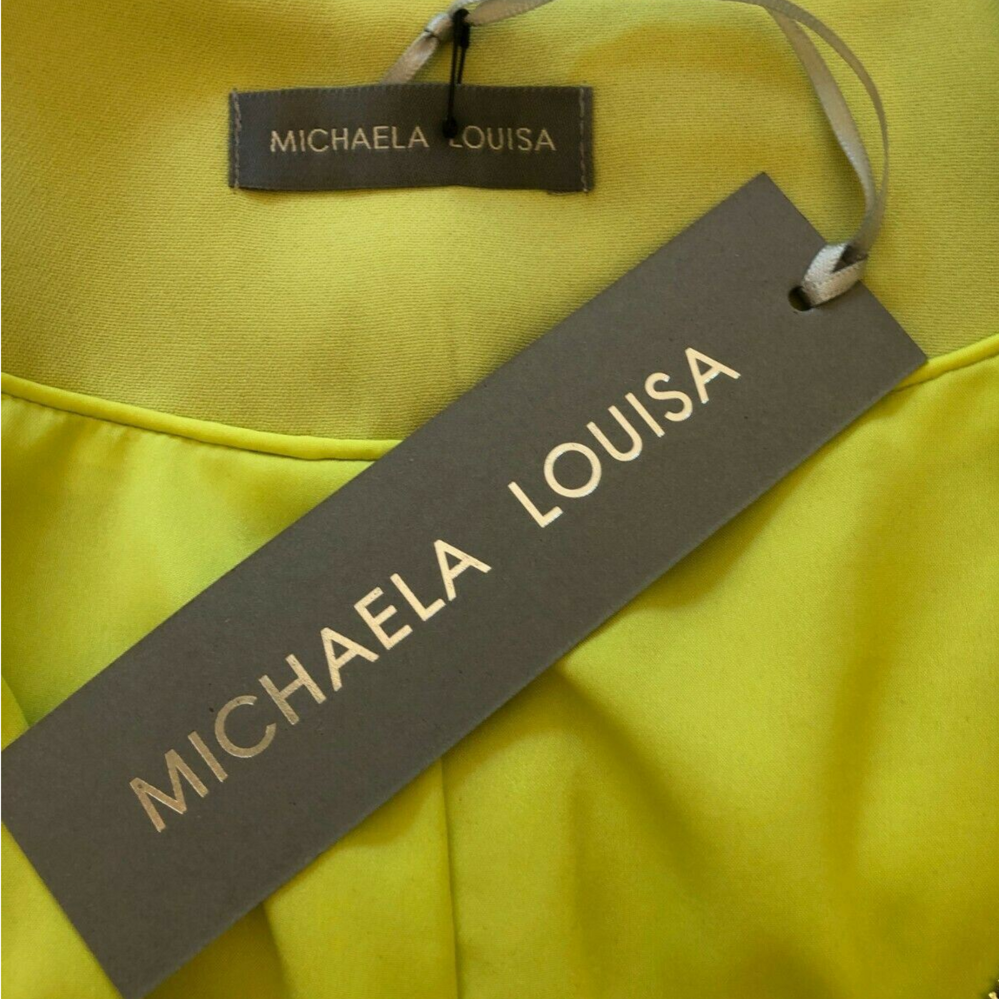 Lime green fabric with a 'MICHAELA LOUISA' tag on a yellow background