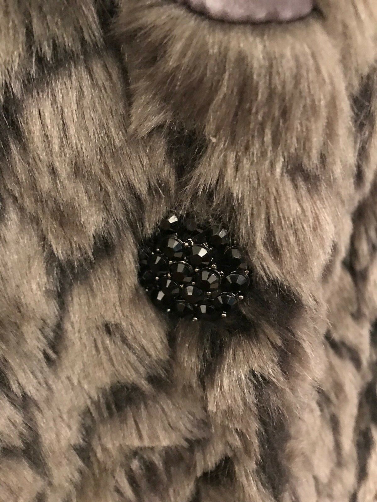Close-up of a black beaded fastener on a fur background