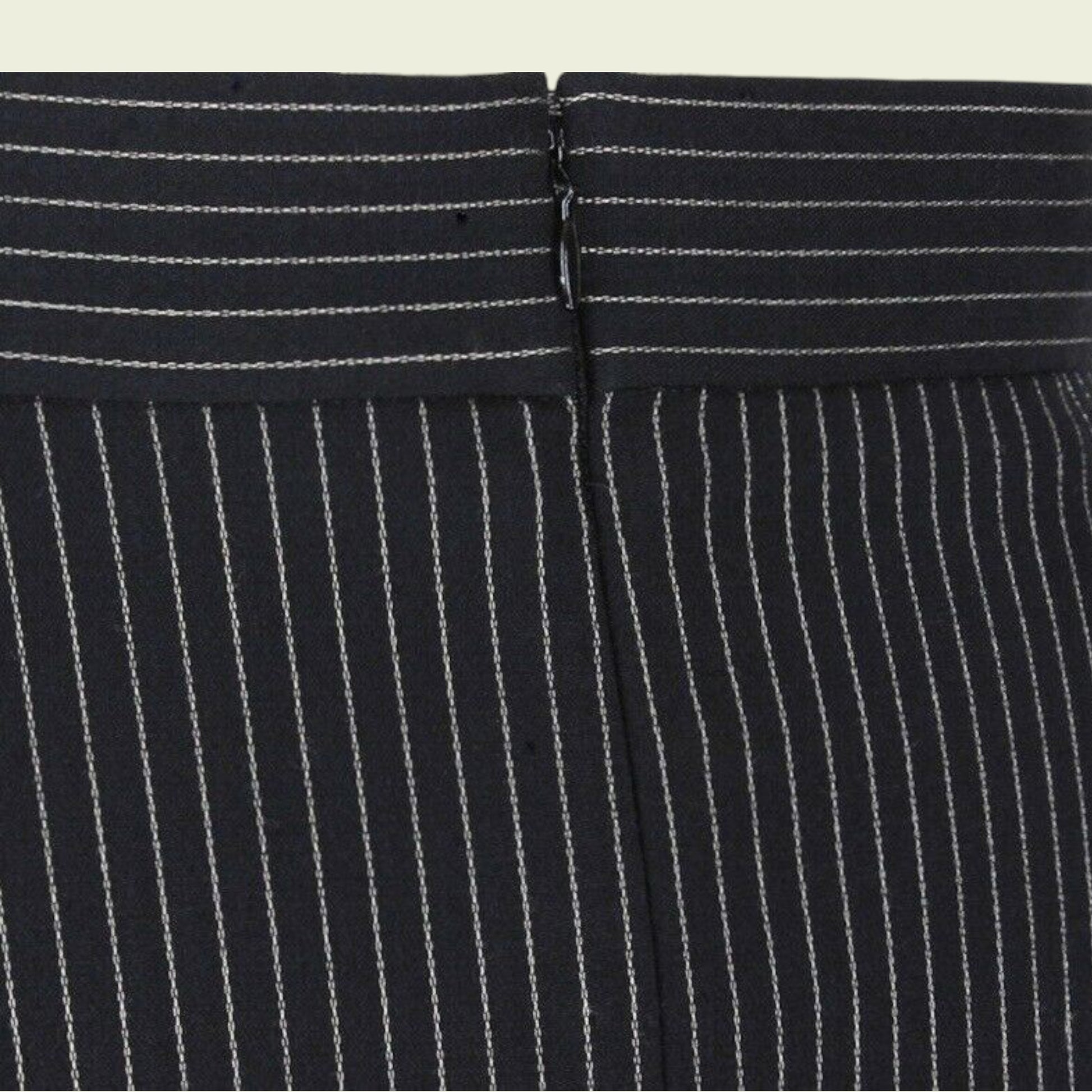 Close-up of a black pinstripe suit with a focus on the waistband.