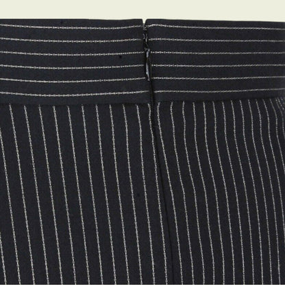 Close-up of a black pinstripe suit with a focus on the waistband.