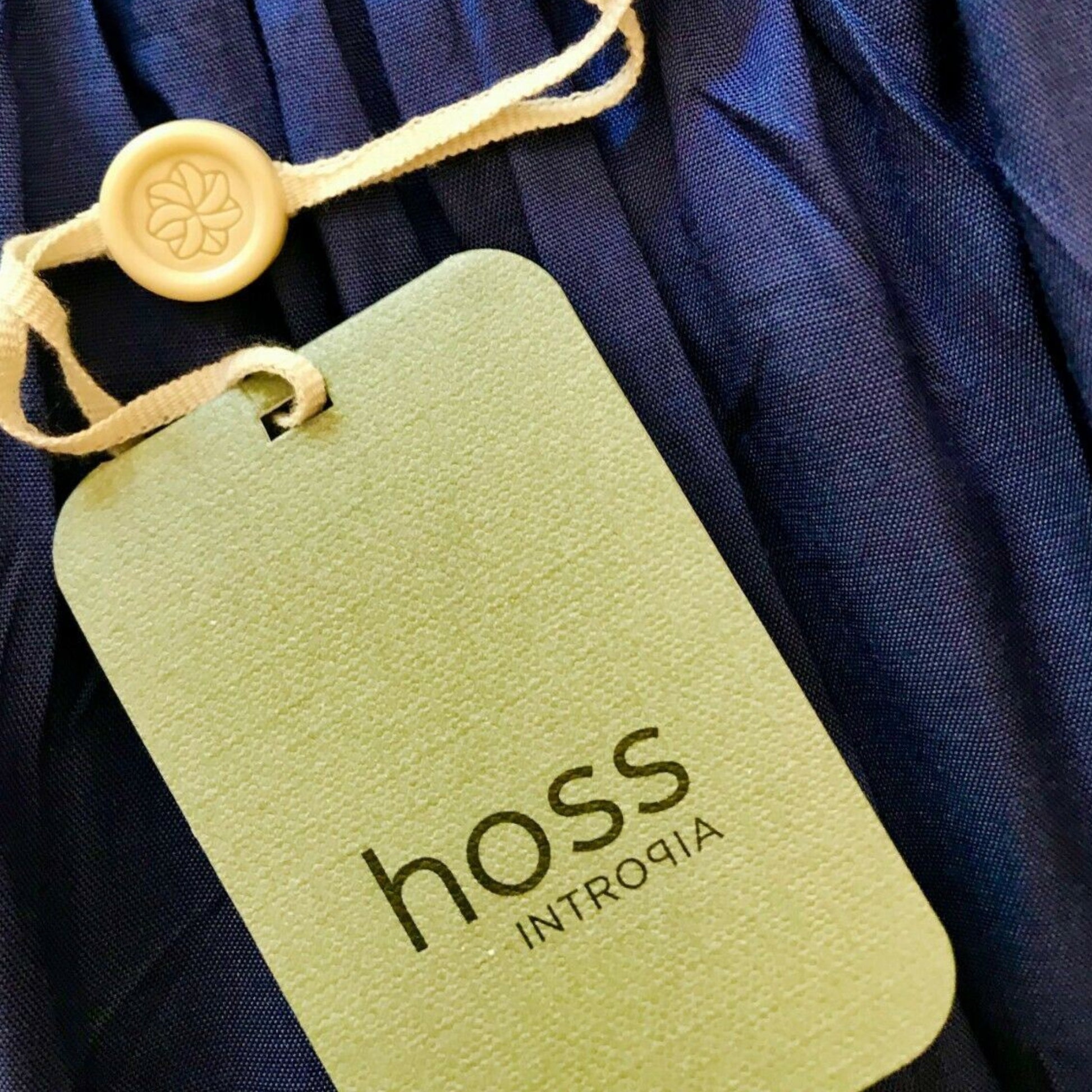 Garment label showing Hoss on product tag on blue background