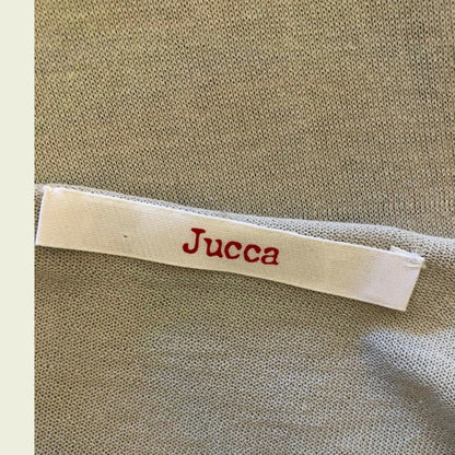 Label with 'Jucca' text on a textured fabric background
