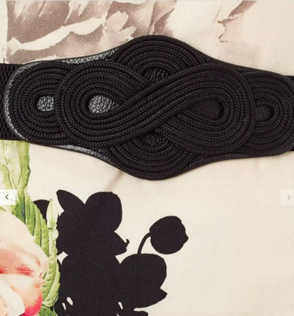 Black woven belt on a floral and abstract background