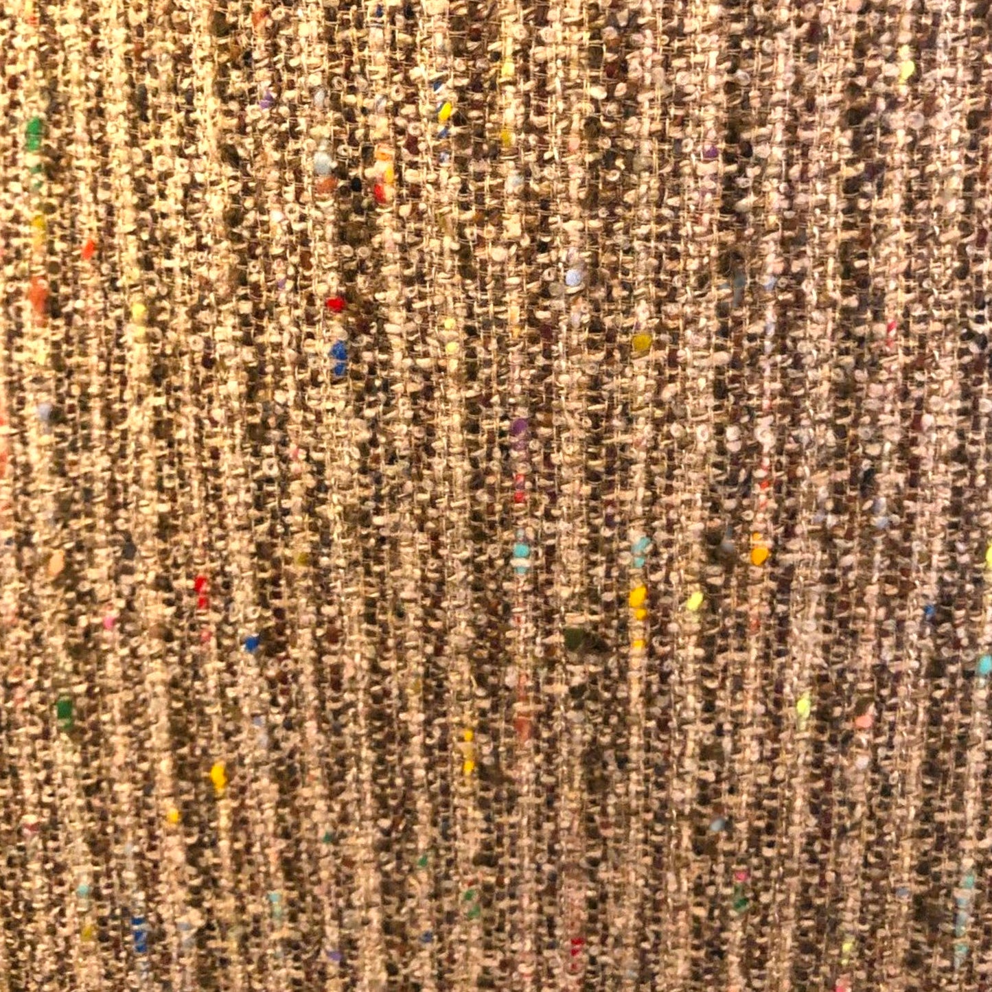Close-up of a textured brown fabric with colorful specks