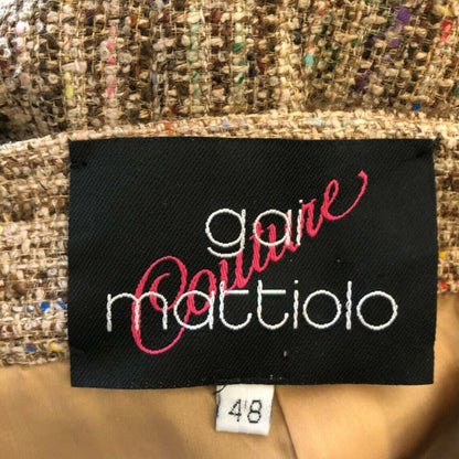 Clothing label with 'gai mattiolo' on a textured fabric background