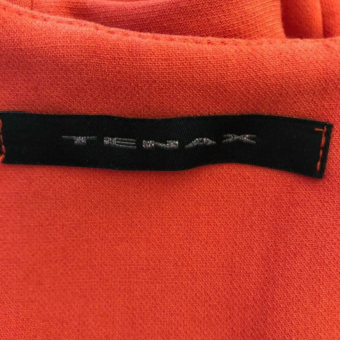 Close-up of a red fabric with a visible brand label.