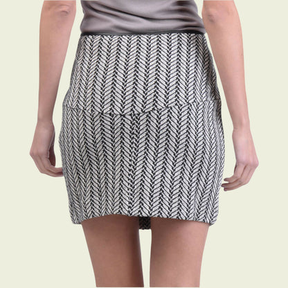 Black and white patterned skirt worn by a person on a beige background