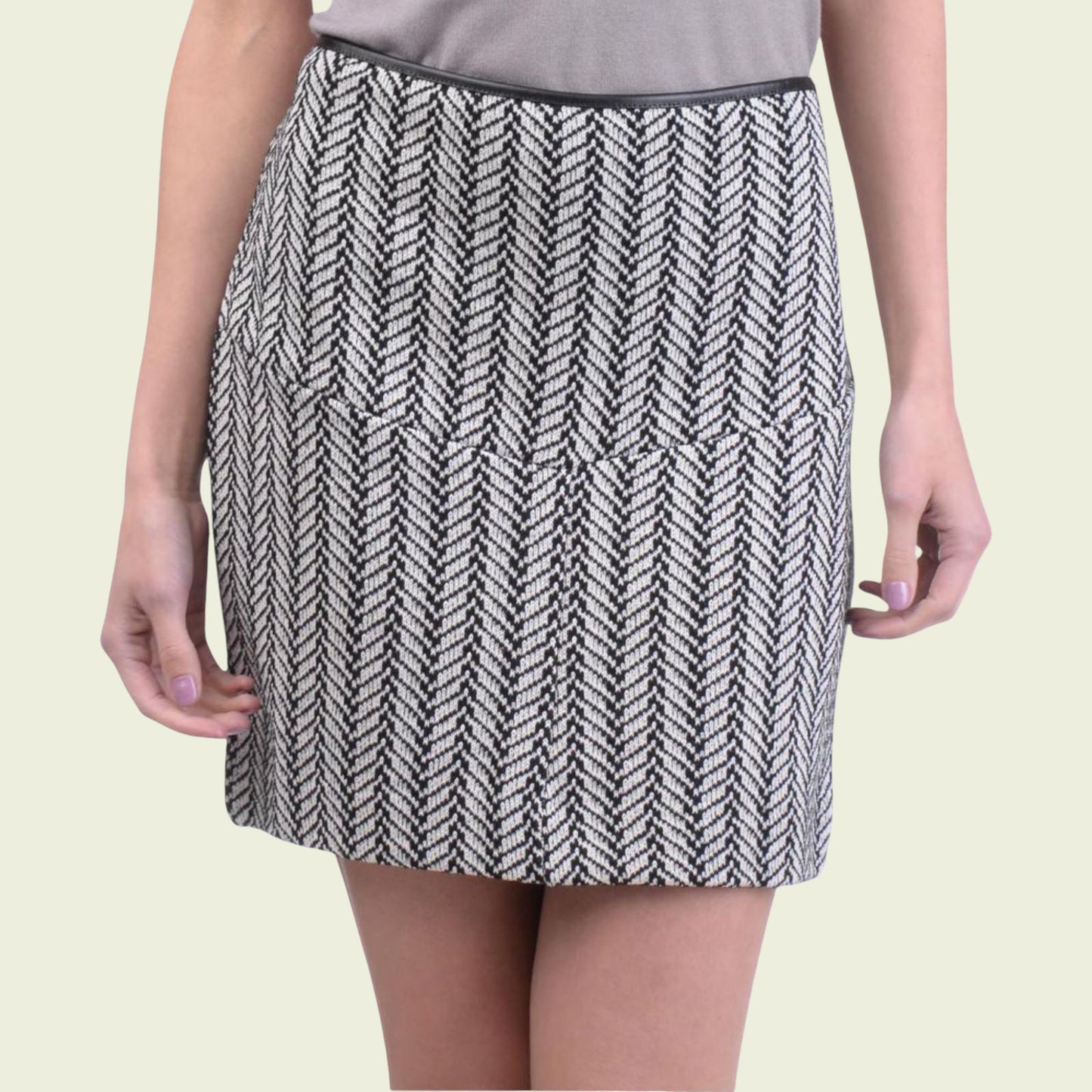 Person wearing a black and white patterned skirt on a beige background