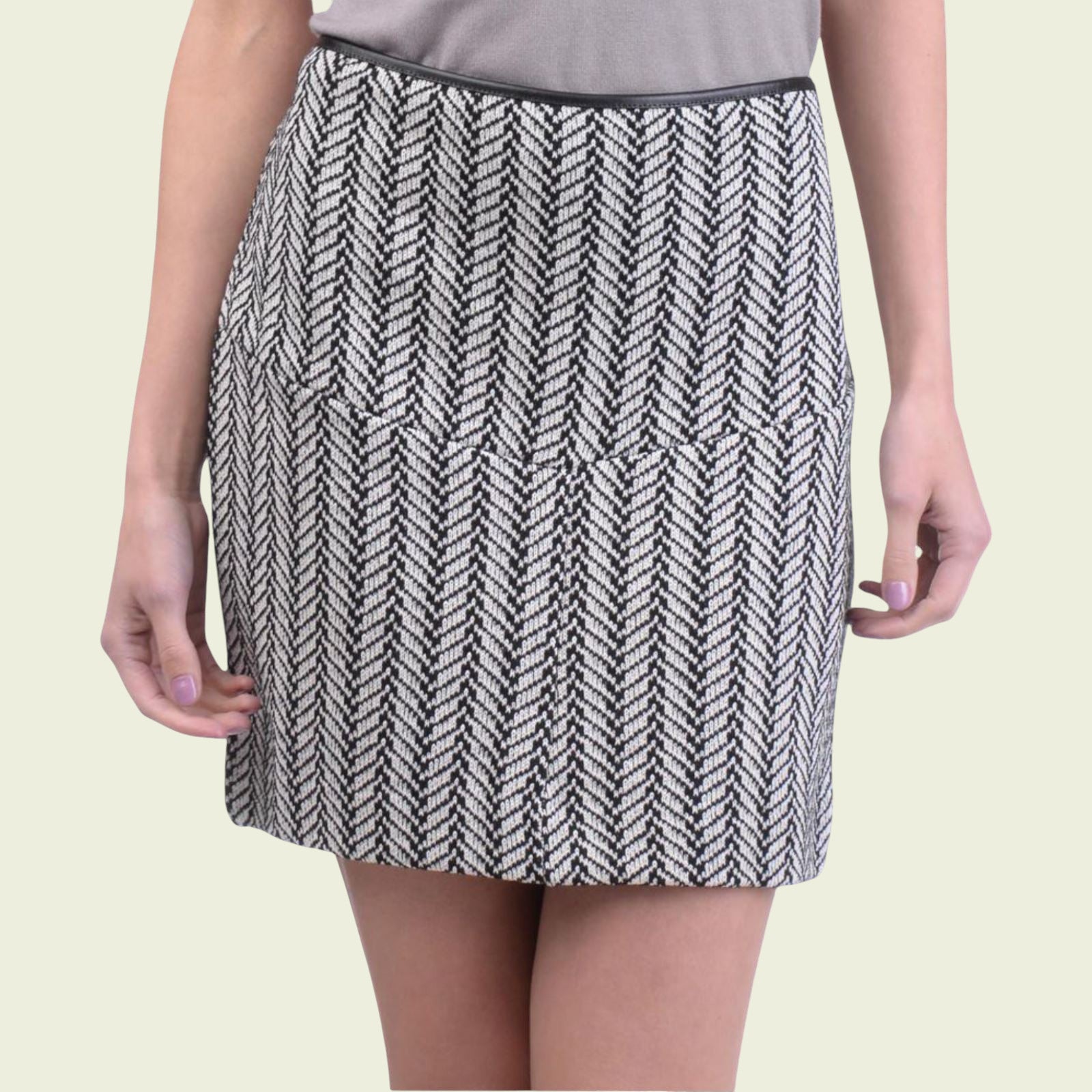 Person wearing a black and white patterned skirt on a beige background