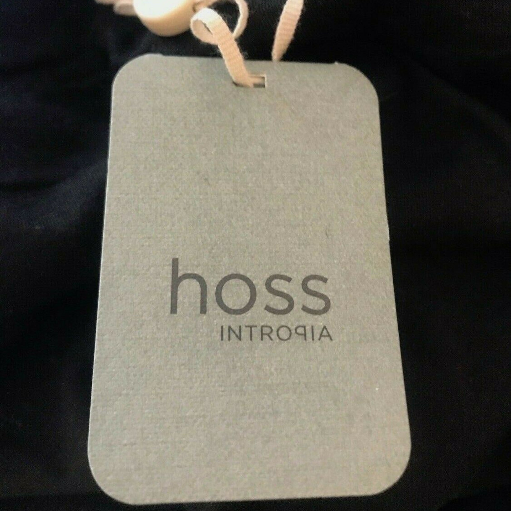Gray tag with 'hoss INTROPIA' text on a dark background