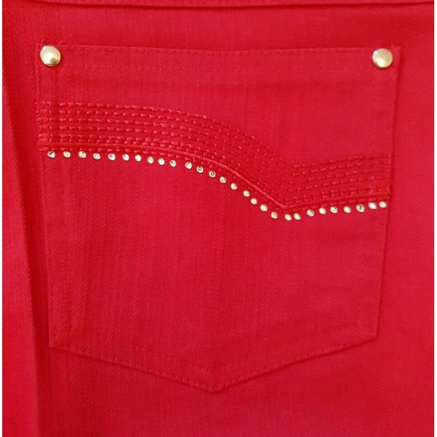 Close-up of a red pocket with decorative studs on a red background