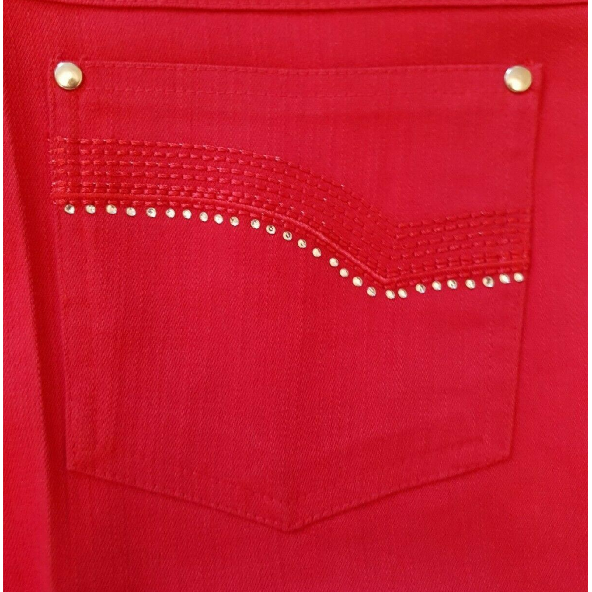 Close-up of a red pocket with decorative studs on a red background