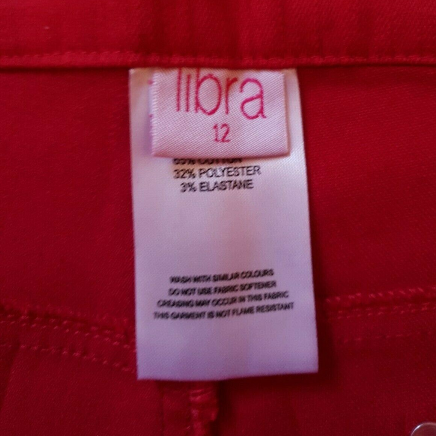 Clothing label with 'libra' brand name on a red fabric background