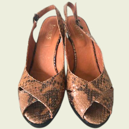 Pair of brown open-toe sandals with snake print on a light background