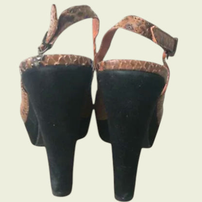 Back of brown open-toe sandals with snake print on a light background