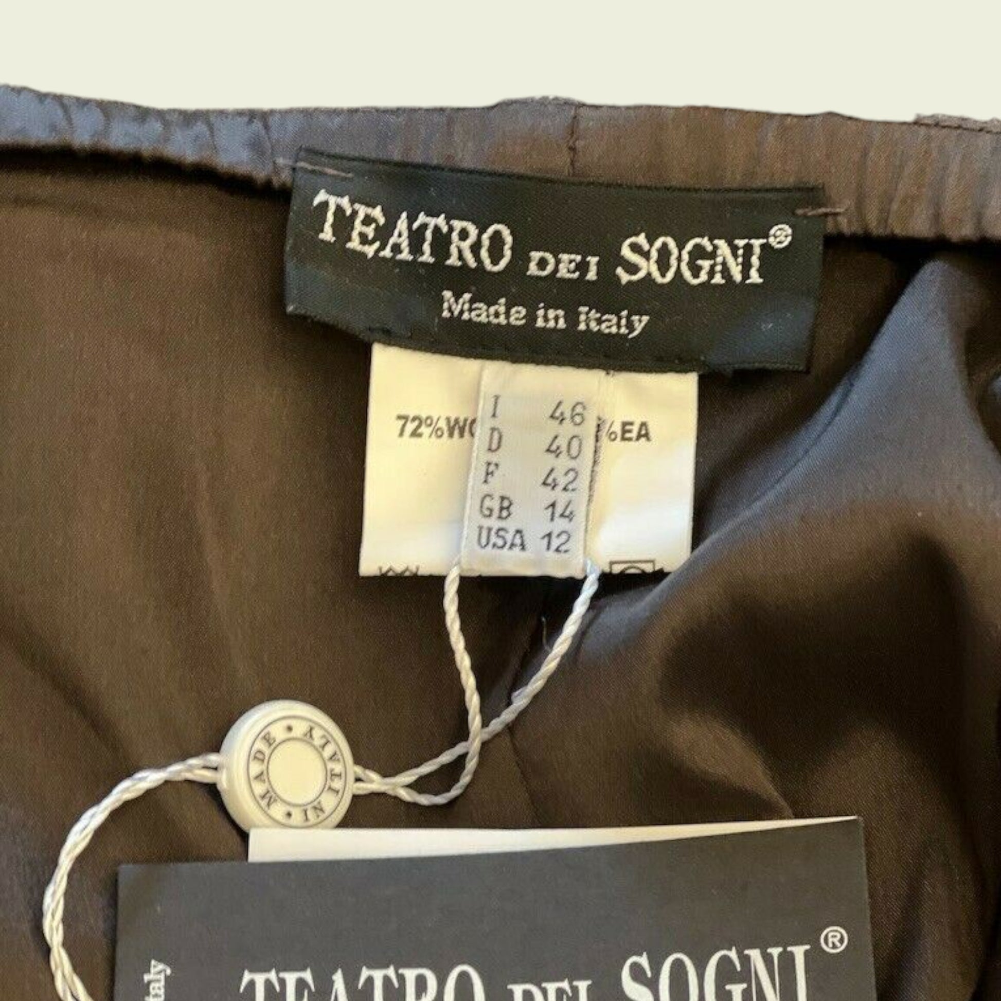 Clothing label with Teatro Dei Sogni and size details on a beige background