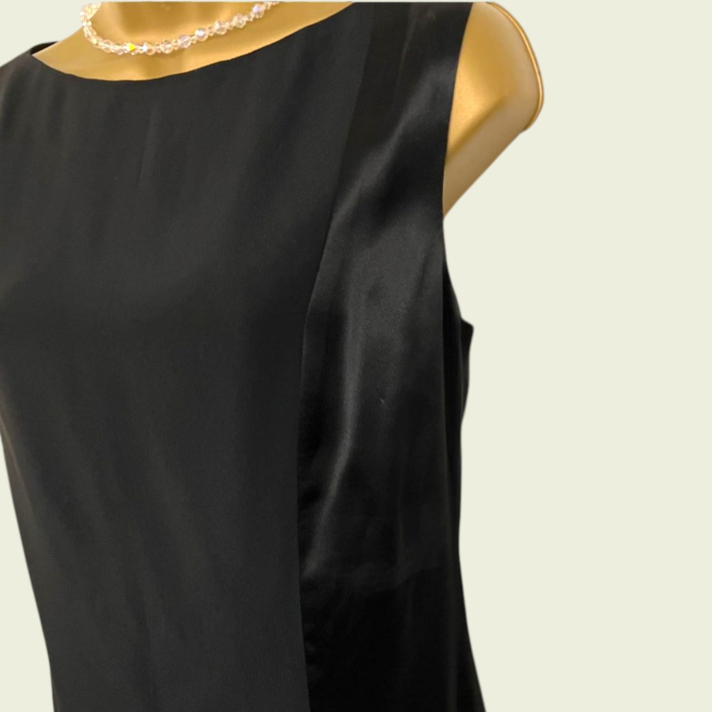 Black sleeveless top on a mannequin against a beige background