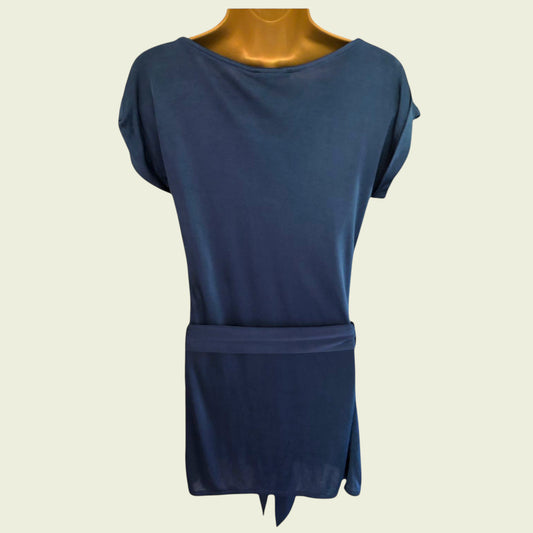 Mannequin wearing a blue silk top on beige background