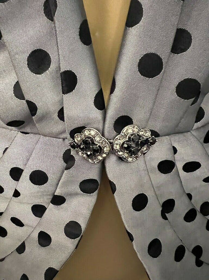 Gray fabric with black polka dots and decorative buttons on a beige background