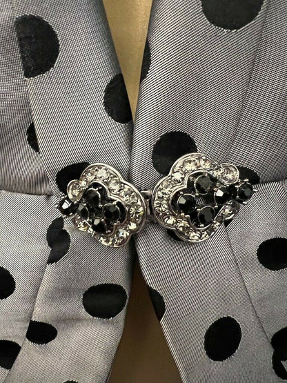 Silver buckle with black stones on a polka dot fabric background