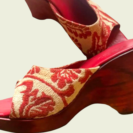 Red and gold patterned high-heeled shoes on a light background