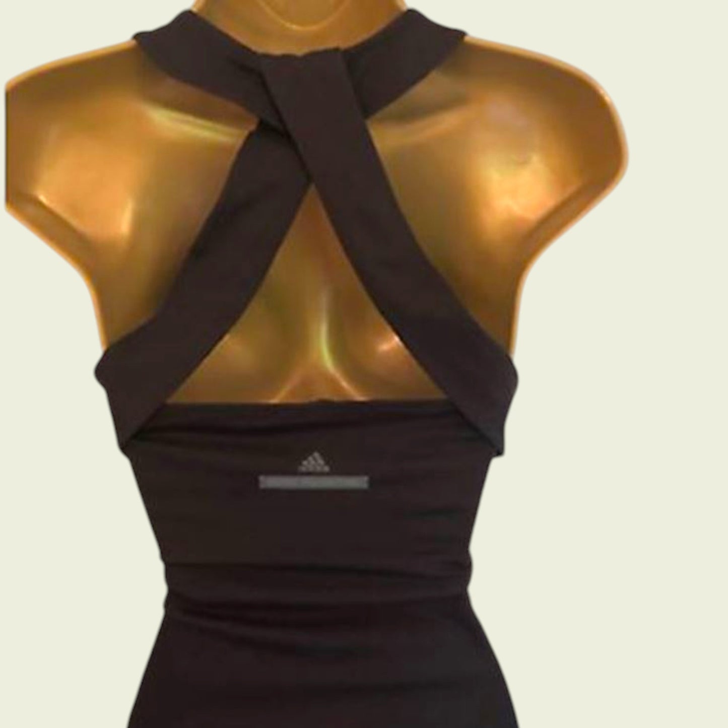 Dark brown Adidas top on a mannequin with a beige background