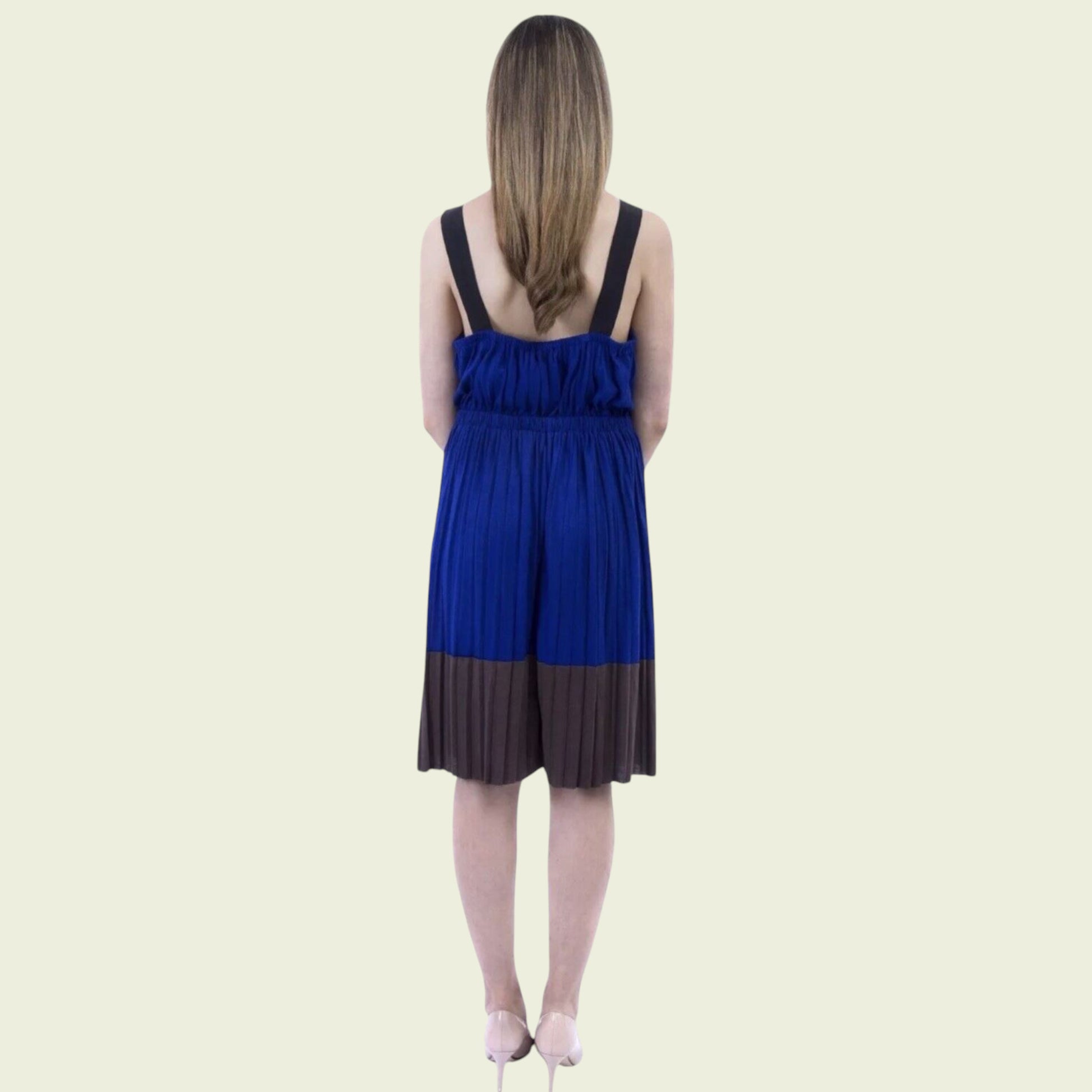 Woman wearing a blue and brown dress on a beige background