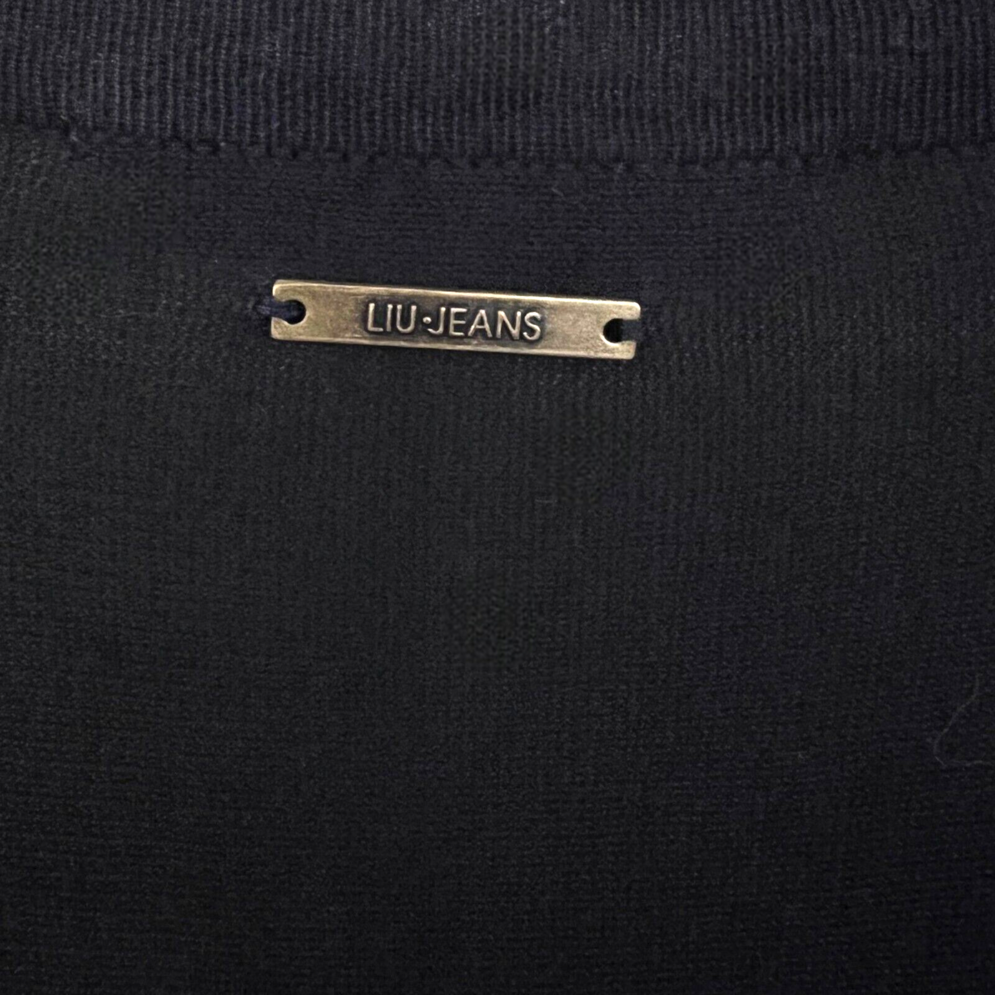 Close-up of a black garment with a 'LIU JEANS' label.