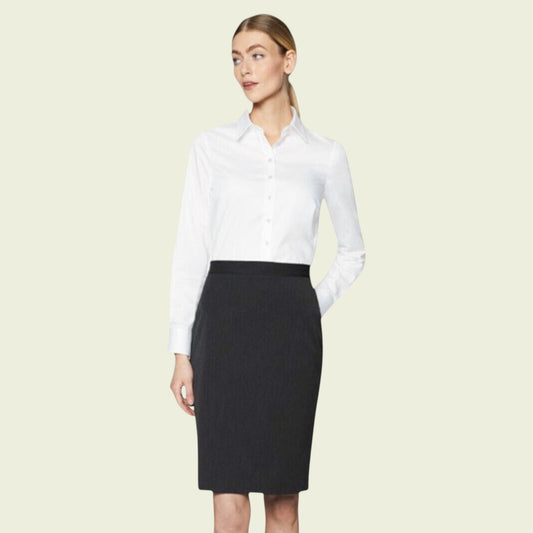 Woman wearing a white shirt and black skirt on a beige background