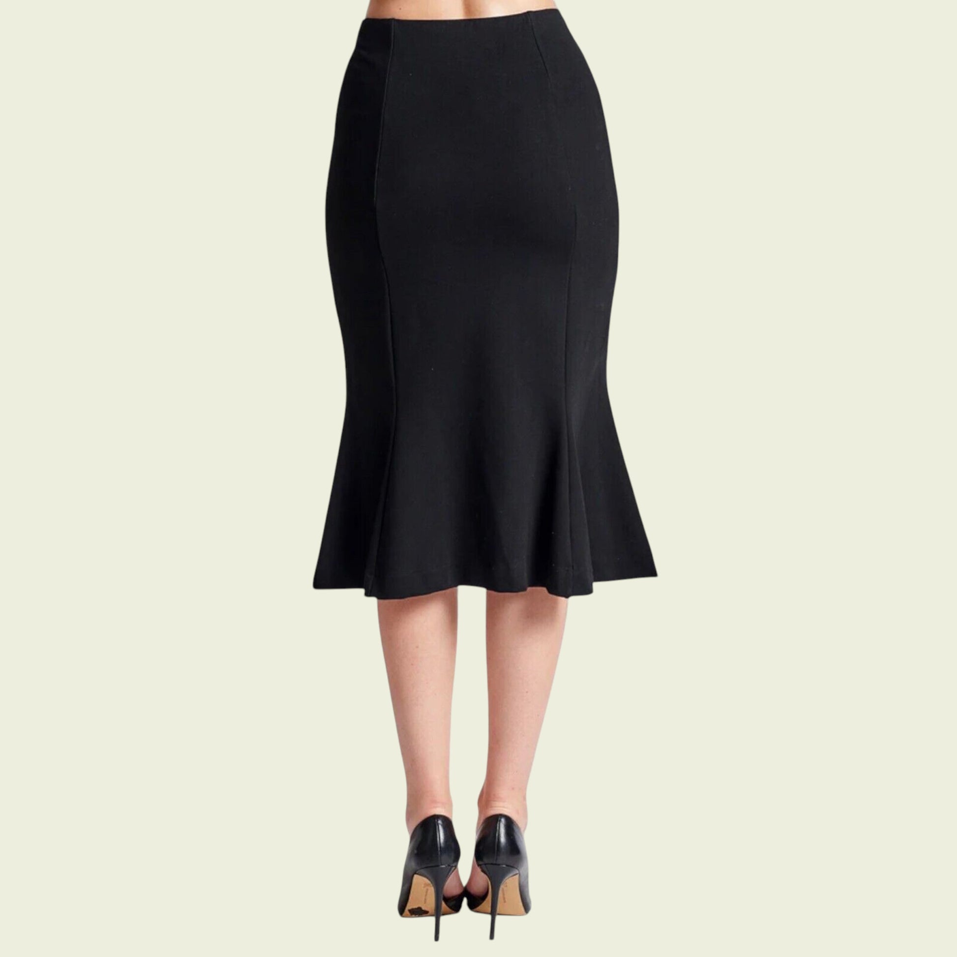 Black pencil skirt worn by a person on a beige background