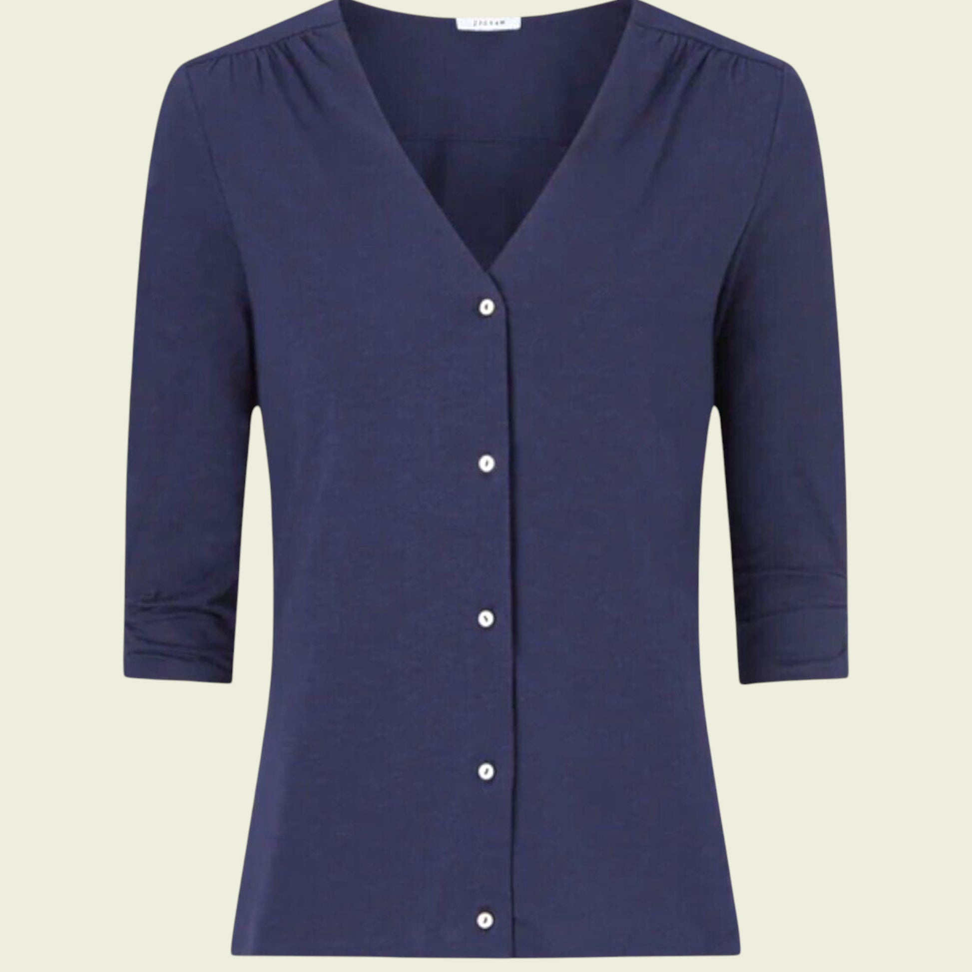 Navy blue carrdigan with buttons on a beige background