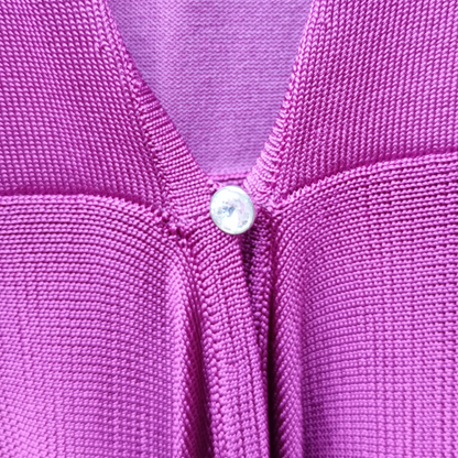 Close-up of a Fuchsia textured fabric with a button in the center.