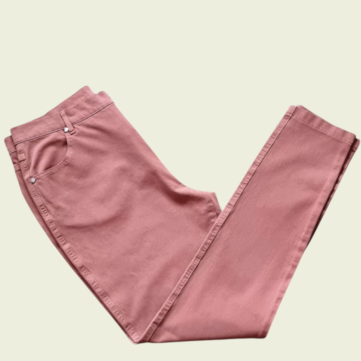 Folded pink pants on a beige background
