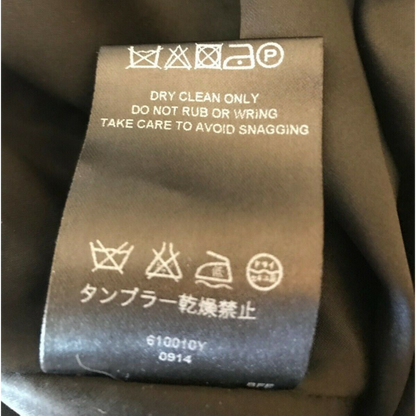 Clothing label with care instructions on a brown fabric background